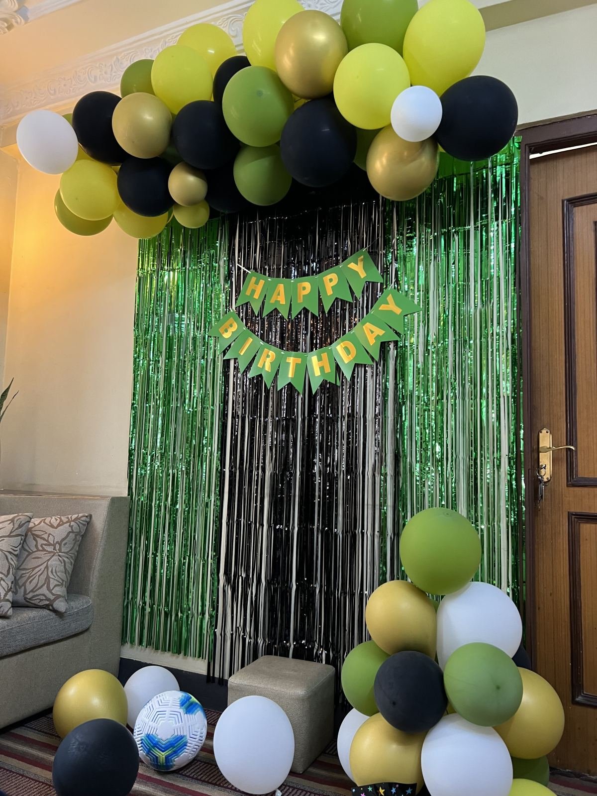 Birthday party balloon decoration in green, black and gold