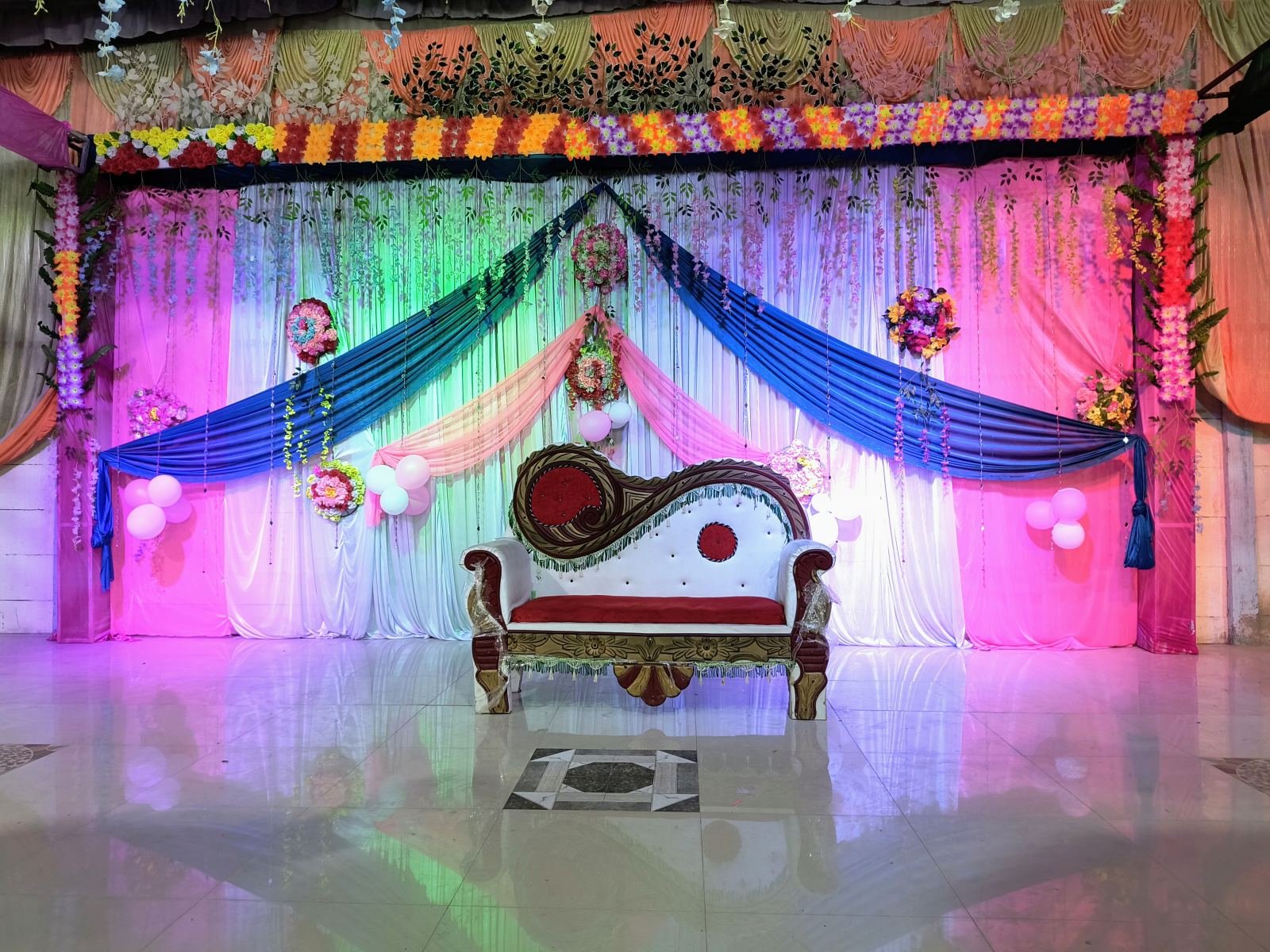 Colourful stage drapes and floral decor for a special occasion