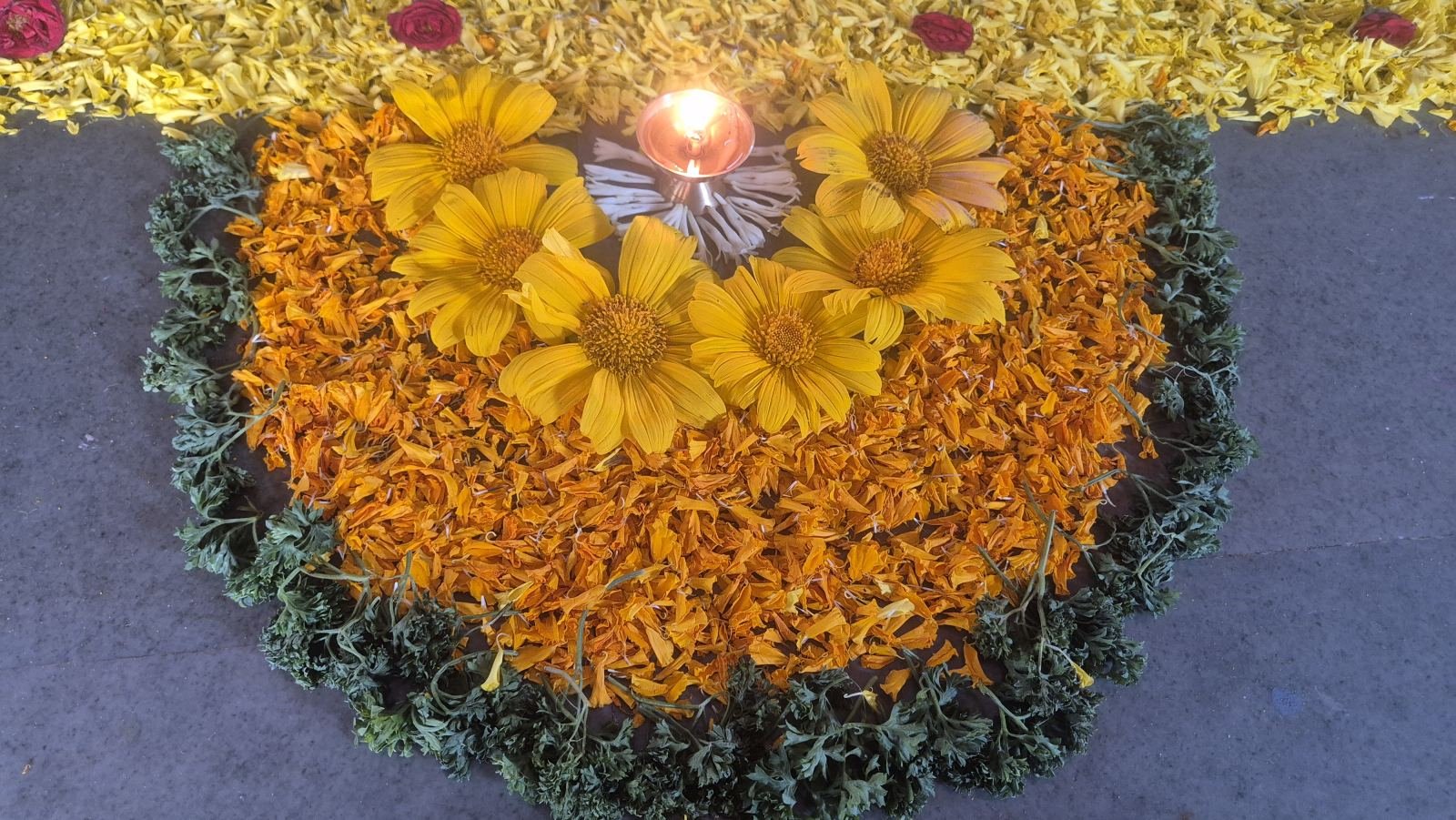 Flower rangoli with a lit diya