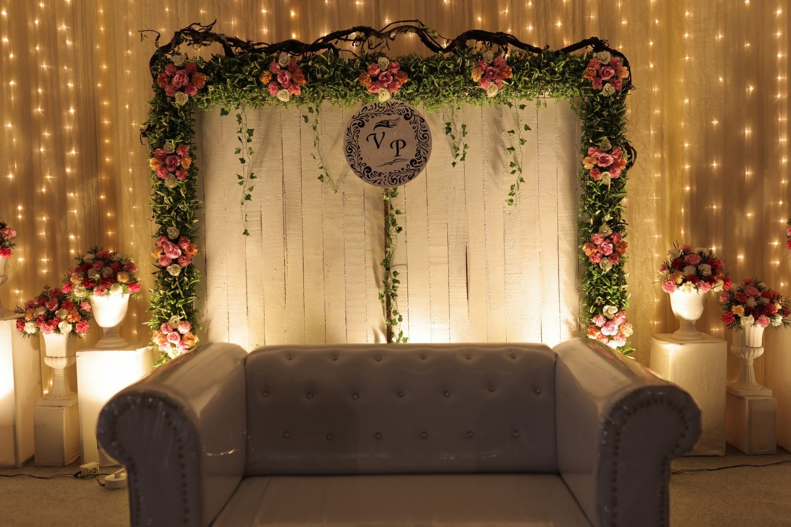 Reception stage with sofa, flowers and warm fairy lights